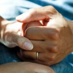 Fighting Cancer and Fostering Hope: Kom Op Tegen Kanker’s Impact in Brussels person wearing gold wedding band
