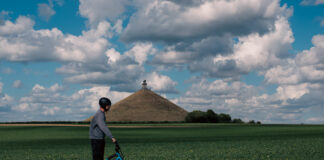 Discover the Brabant Countryside Person riding an electric scooter near the Butte du Lion in Waterloo with Trott e Vibe