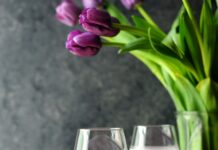 Blueberries: The Powerful Superfood for Heart, Brain, and Long-Term Health Blueberry smoothie in wine glasses with fresh blueberries and purple tulips in the background