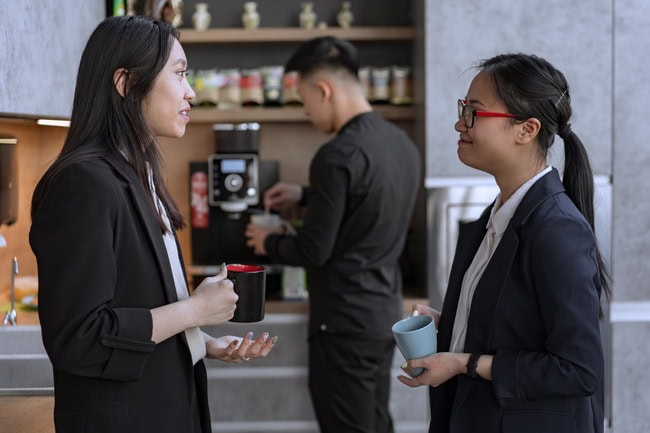 Colleagues talking during a break. Illustrative stock photograph. Photo: Mikhail Nilov / Pexels.